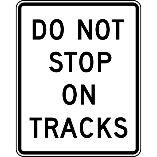 A white rectangle sign with a black border and the black words DO NOT STOP ON TRACKS.
